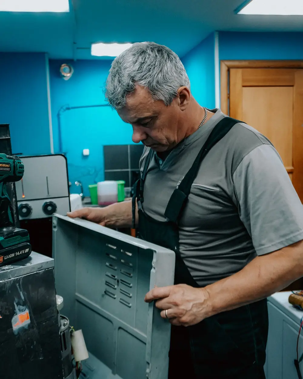 Technician removing the back panel of an appliance